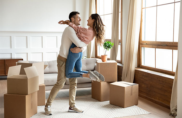 man and woman hugging in living room of their new home